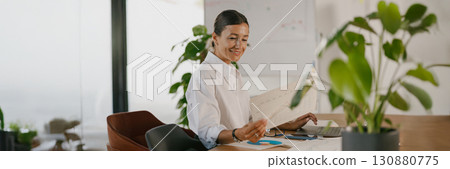 A professional woman engaged in her work in a modern office designed for productivity 130880775