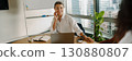 A professional woman confidently working in a modern office environment and setting 130880807