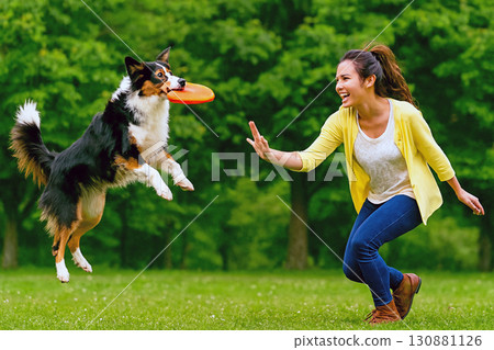 Woman and puppy playing frisbee 130881126