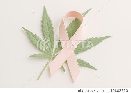 Pink awareness ribbon placed on green cannabis leaves, symbolizing health, wellness, and support for cancer awareness, promoting a message of hope and healing in a serene setting Pink awareness ribbon placed on green cannabis leaves, symbolizing health, wellness, and support for cancer awareness, promoting a message of hope and healing in a serene setting 130882210