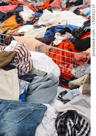 jeans and shirts filling bins at a busy outdoor stall 130883214