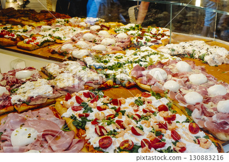 assorted pizza al taglio in an italian pizza shop 130883216