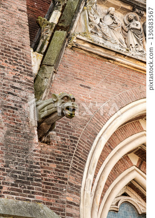 Architectural detail of a stone gargoyle on a historic building with intricate carvings and textures 130883567