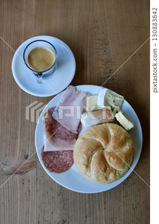 European cafe-style breakfast: A table with bread, ham and coffee 130883642