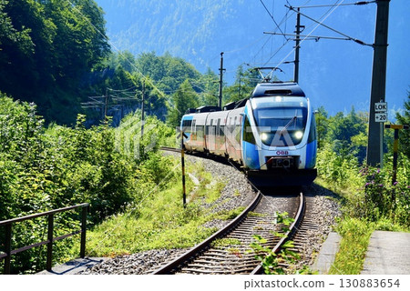 European train scenery heading towards Hallstatt with Alps mountains and lake in the background 130883654
