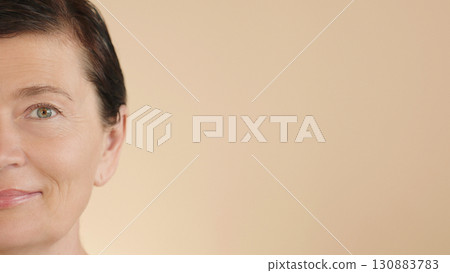 Surprised face mature middle aged woman with wet hair and glowing face, perfect skin. Ads rejuvenating skin care products, makeup for natural glowing healthy skin, vision correction. Copy space. 130883783
