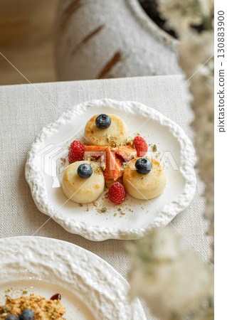 Syrniki pancakes with berries and pistachios Syrniki pancakes with berries and pistachios 130883900
