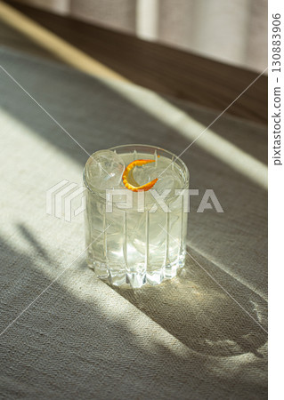 Gin and tonic cocktail with ice in faceted glass Gin and tonic cocktail with ice in faceted glass 130883906