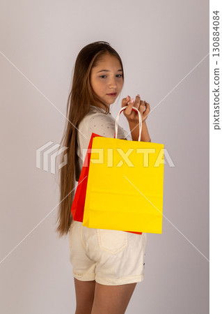 Young girl holding yellow shopping bag Young girl holding yellow shopping bag 130884084