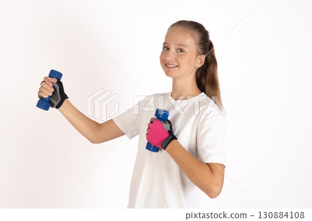 Girl in white T-shirt and blue gloves holds blue foam roller Girl in white T-shirt and blue gloves holds blue foam roller 130884108