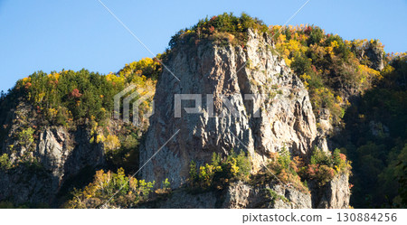 Autumn scenery of Hokkaido's Sounkyo with a pleasant blue sky Autumn scenery of Hokkaido's Sounkyo with a pleasant blue sky 130884256