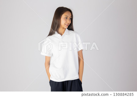 Young girl in white shirt and black shorts. 130884285