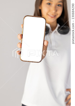Woman holding a phone with a blank screen Woman holding a phone with a blank screen 130884290