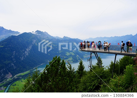 A spectacular view of Lake Brienz and the Alps from the summit of Harderkulm. A travel scene from Switzerland. A spectacular view of Lake Brienz and the Alps from the summit of Harderkulm. A travel scene from Switzerland. 130884366