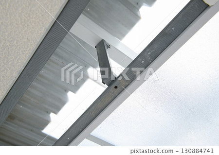 Precise construction detail of metal support for transparent awning during house renovation project. sturdy framework shows modern building technique and design Precise construction detail of metal support for transparent awning during house renovation project. sturdy framework shows modern building technique and design 130884741