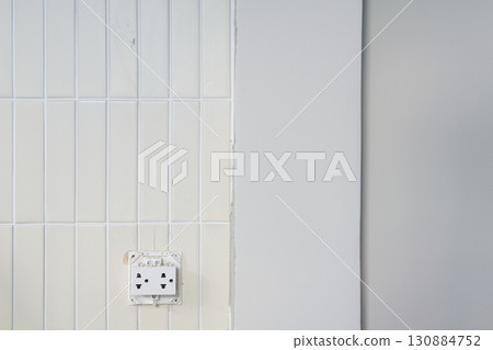 Minimalist detail view of house renovation project showing wall construction. unfinished surface next to white tile creates sense of progress and anticipation Minimalist detail view of house renovation project showing wall construction. unfinished surface next to white tile creates sense of progress and anticipation 130884752