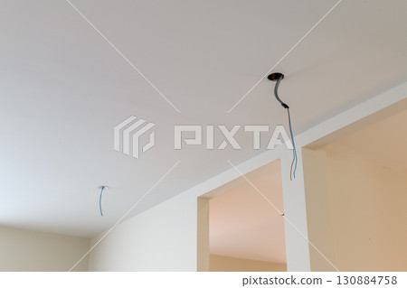 Close up detail of electrical wire on ceiling during house renovation. construction site interior shows an unfinished room with sense of hopeful progress 130884758
