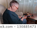 an older adult woman utilizing a handheld glucometer to test her blood sugar levels from the comfort of her own home 130885473
