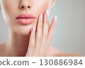 Beautiful female mouth and hands. Beauty concept close-up highlighting pink nails and glossy lips 130886984