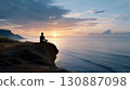 一名男子在懸崖上冥想，觀看日出的輪廓 130887098