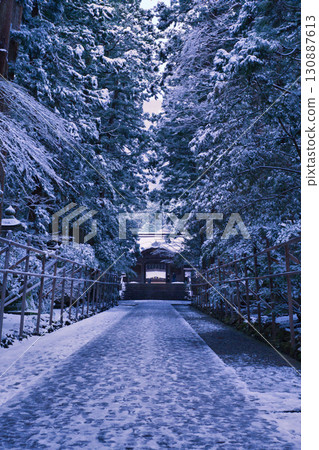 Snow piles up on the approach to Yahiko Shrine, creating a mystical atmosphere. 130887613