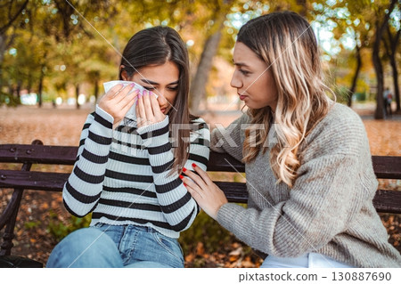 Friends share an emotional moment in a beautiful autumn park scene 130887690
