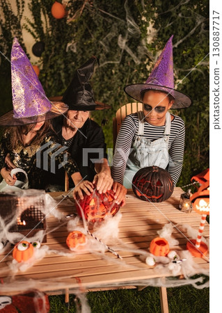 Three generations family carving pumpkins for Halloween party 130887717