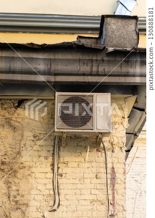 old and dusty air conditioner on the facade of a brick house. air ventilation and cooling system. old and dusty air conditioner on the facade of a brick house. air ventilation and cooling system. 130888181