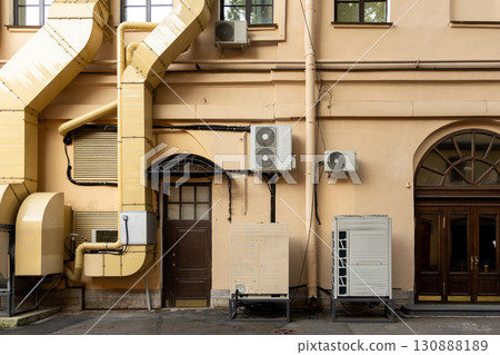 Air conditioners on the facade of yellow historical house. An air ventilation and cooling system. Air conditioners on the facade of yellow historical house. An air ventilation and cooling system. 130888189