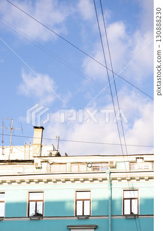 Urban life, a house with blue walls after restoration. A blue sky with a few clouds. 130888230
