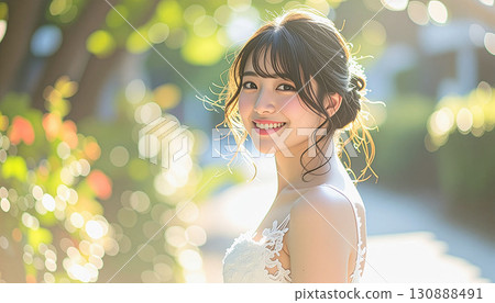 Smiling young bride in wedding dress outdoors 130888491