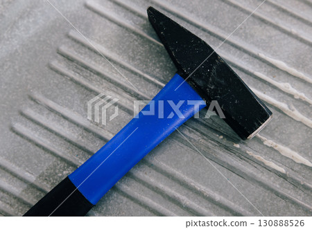 Close-up of a black hammer with a blue handle Close-up of a black hammer with a blue handle 130888526