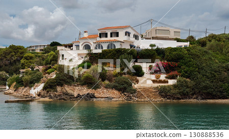 White villa with terracotta roof and arched windows on a green hillside. Menorca, Mahon 130888536
