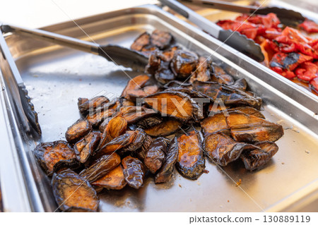 Baked eggplants on a tray at a barbecue buffet. 130889119