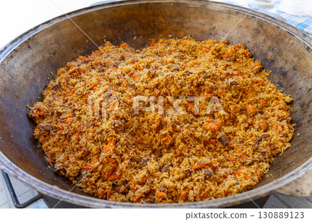 A large metal cauldron with freshly prepared Uzbek pilaf 130889123