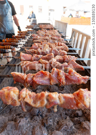 Sizzling skewers of marinated meat grilling over hot coals 130889130