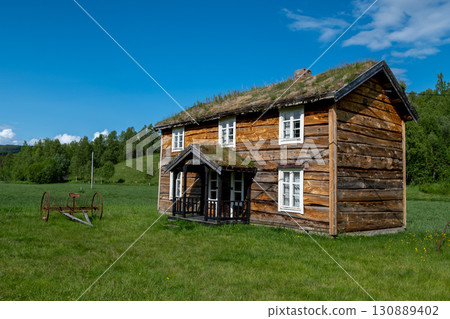 Old Wooden Farmhouse With Rusty Agricultural Equipment On Lofoten Islands In Norway 130889402