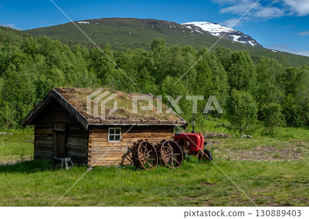 Old Wooden Farmhouse With Rusty Agricultural Equipment On Lofoten Islands In Norway 130889403