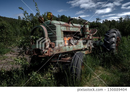 Rusty Vintage Tractor In Rural Landscape Of Lofoten Islands In Norway Rusty Vintage Tractor In Rural Landscape Of Lofoten Islands In Norway 130889404