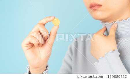 Woman taking medical lozenges with honey lemon flavored for relief sore throat, irritating cough and mouth pain. Close up of female feeling sick and cold over light blue backgroud. Health care. 130889532