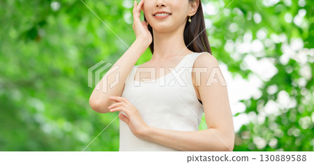 A woman standing in fresh greenery - beauty image 130889588