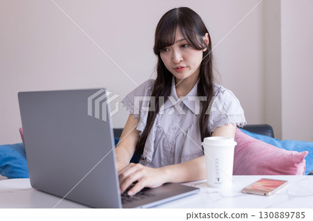 A Japanese woman working on a PC in the living room A Japanese woman working on a PC in the living room 130889785