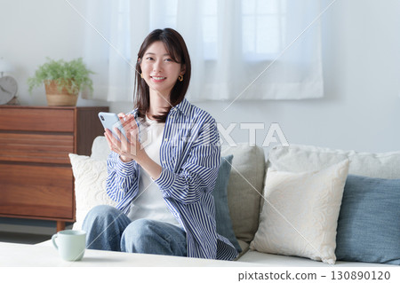 使用智慧型手機的微笑年輕女子 130890120