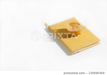 Thai iced tea placed on notebook on minimal white table under summer hard light 130890369