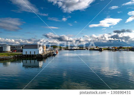 Harbor With Small Ships Of Sommaroy In Front Of Snowy Mountains In Norway 130890431