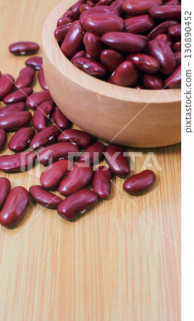 Red kidney beans in a wooden bowl with beans scattered on wooden table, healthy organic food and natural plant-based protein. 130890452