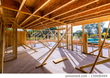 Construction site showcasing wooden framing support beams during daylight at residential building project Construction site showcasing wooden framing support beams during daylight at residential building project 130890484