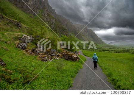 Woman Hikes On Abandoned Trail Near Village Bleik On Andoya Island Of Lofoten In Norway Woman Hikes On Abandoned Trail Near Village Bleik On Andoya Island Of Lofoten In Norway 130890857
