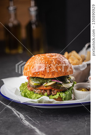 Tasty cheeseburger with fries, sauces and salad 130890929