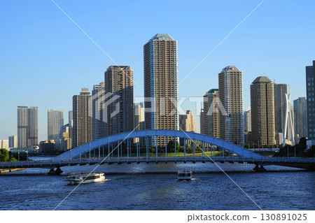 Eitai Bridge and high-rise apartment buildings across the Sumida River under a blue sky. July Chuo 790 Eitai Bridge and River City 21 and other high-rise buildings. Eitai Bridge and high-rise apartment buildings across the Sumida River under a blue sky. July Chuo 790 Eitai Bridge and River City 21 and other high-rise buildings. 130891025